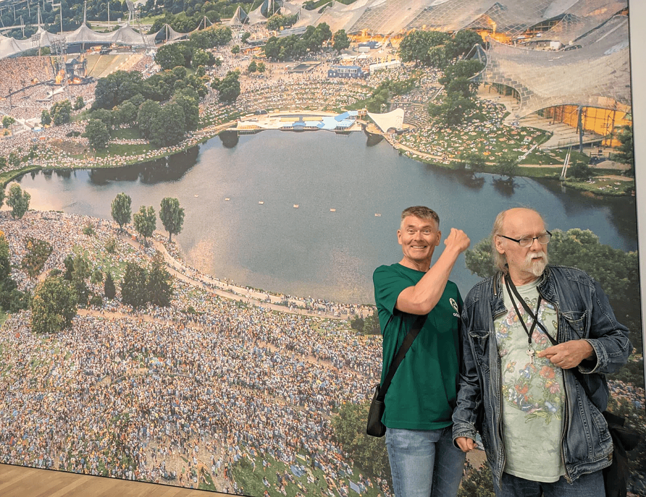 Viele Menschen im Olympiapark und auf dem Olympiaberg. Klaus zeigt den Treffpunkt von dem nächsten Treffen.
